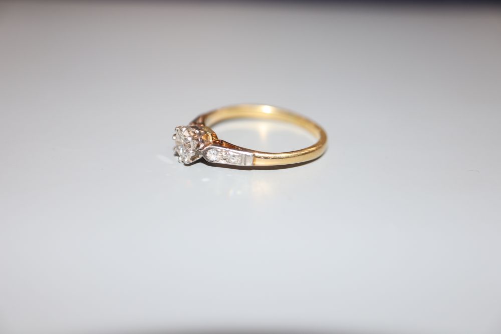 A yellow metal and single stone diamond ring, with diamond set shoulders, size O, gross 2.5 grams.